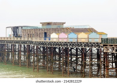 Hastings Pier, East Sussex, UK Showing Beach Huts And Space For Text On Overcast Grey Spring Day 28 MARCH 2022 No People