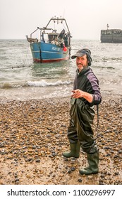 Hastings UK 09/27/2017 Fisherman Bringing Commercial Fishing Boat Ashore Onto Shingle Beach