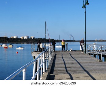 Hastings, Victoria, Australia 05/05/2017.   People fishing from the jetty in Hastings, Victoria with LPG gas storage tanks in the background