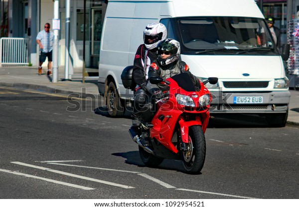 Hastings,East Sussex/UK 07/05/18 Bike 1066 the\
annual May Day bike run to Hastings. A red Kawasaki motorcycle with\
pillion passenger arrives on the seafront to join thousands of\
other motorbikes