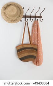 Hat, Bag And Scarf Hanging On Hook Against White Wall