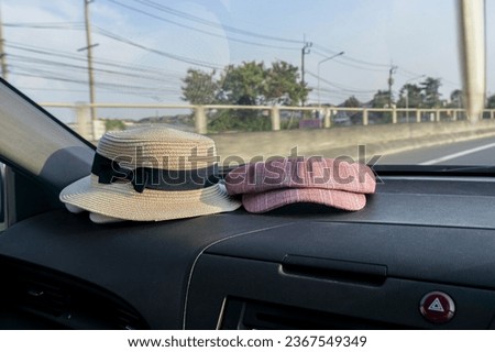 A hat on console car and the highway in front of car in sunny day
