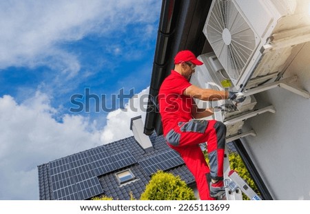 Hat Pump and Air Condition Scheduled Maintenance Performed by Caucasian HVAC Technician in His 40s.