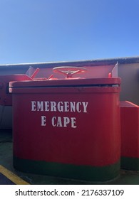 Hatch Cover Of The Emergency Escape Door On The Ship With Red Color And The Words 