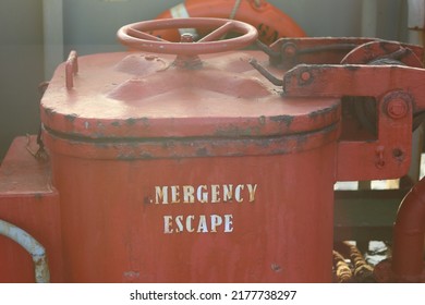 Hatch Cover Of The Emergency Escape Door On The Ship With Red Color And The Words 