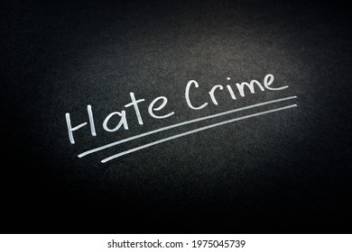 Hate crime words on the dark surface. - Shutterstock ID 1975045739