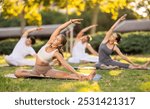 Hatha yoga coach conduct leading rehearsal for girls and guys in park, show example of performing exercises, do fulfil Parivritta Janu Shirshasana. People practice sport during yoga workout in nature