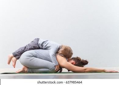 Hatha yoga fitness mother with baby