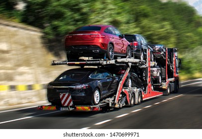 Hauling cars. A car carrier trailer, known variously as a car-carrying trailer, car hauler, auto transport trailer.New and very expensive cars transportation.  - Shutterstock ID 1470699971
