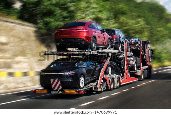 Hauling cars. A car carrier\
trailer, known variously as a car-carrying trailer, car hauler,\
auto transport trailer.New and very expensive cars transportation.\
