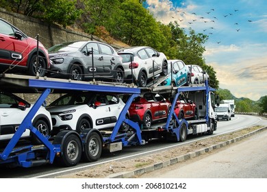Hauling cars. Car carrier. Truck carrying cars. Car carrier transporter truck on road. Auto vehicles hauler on driveway.  No logo or brand.