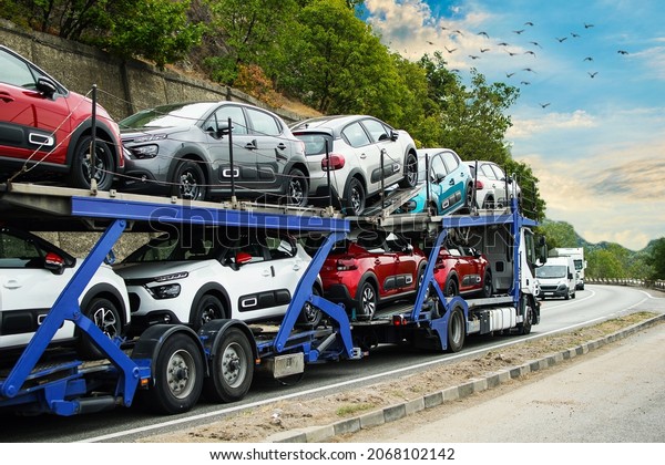 Hauling cars. Car carrier. Truck carrying cars.\
Car carrier transporter truck on road. Auto vehicles hauler on\
driveway.  No logo or\
brand.