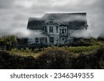 A haunted house surrounded by fog and a corn field 