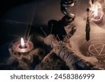 A haunting occult setup featuring a pendulum, mystical symbols, candles, a voodoo doll, and a ritual goblet amidst swirling smoke