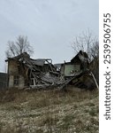 A hauntingly beautiful image of an old, abandoned farmhouse in the Norwegian countryside. The large, weathered structure shows the wear of time, with the roof collapsed and signs of decay throughout. 