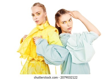 Haute couture clothing. Fashion models girls pose in stylish clothes from the summer collection. Studio portrait on a white background.