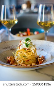 haute cuisine dish with spaghetti with lobster, buffalo stracciatella and a fine white wine. In a luxurious Italian restaurant - Shutterstock ID 1590361336
