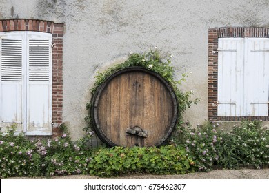 HAUTVILLERS, FRANCE - JUNE 27, 2017: End Of Wine Barrel Used For Decoration On Facade Of House With White Shutters. 