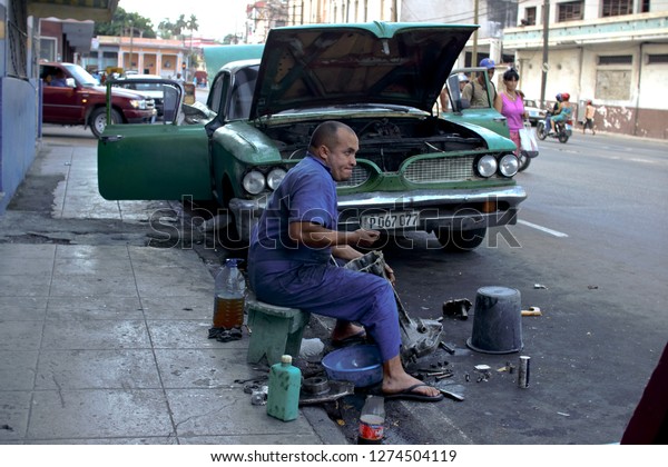 Havana, Cuba. 02/09/2014 A man repairs his old\
car on the street of Havana. Repair of an old American car. Rare\
car made in the USA of the 50s in Cuba. Car repair shop on the\
street. Editorial.