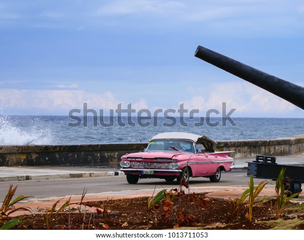 Havana, Cuba, 02.22.2017: a pink vintage\
cabriolet car driving along the Malecon.\
