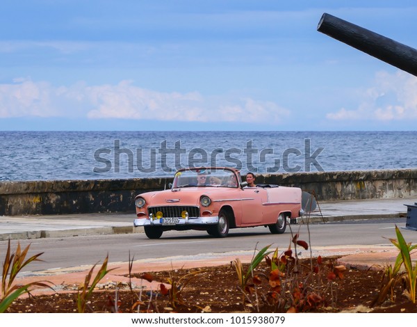Havana, Cuba, 02.22.2017: a pink vintage
cabriolet car driving along the
Malecon.