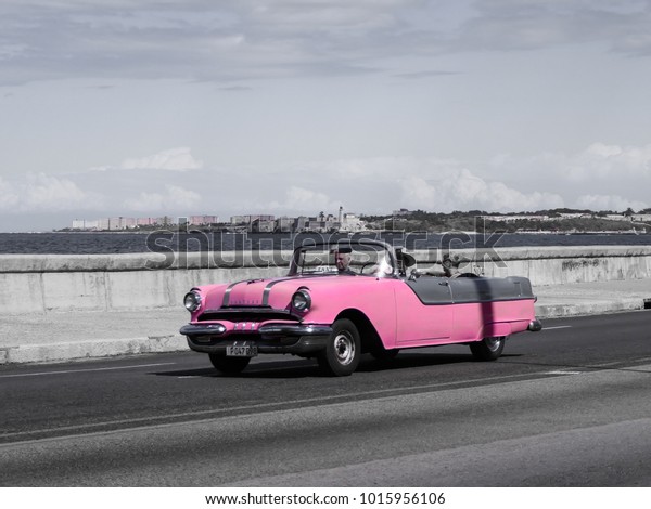 Havana, Cuba, 02.22.2017: a pink vintage\
cabriolet car driving along the\
Malecon.