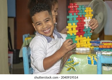 HAVANA, CUBA - Apr 02, 2019: A Smiling Cuban Child Boy In Kindergarten Playing With Baby Cubes At Recess In Havana, Cuba