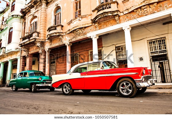 Havana, Cuba -\
December 11, 2016: Red Old American Classic Cars with Cuba Flag in\
the streets of Old Havana,\
Cuba