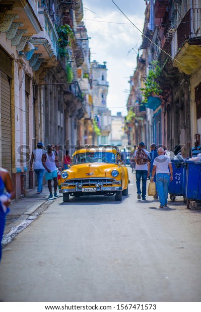HAVANA, CUBA - DECEMBER 2, 2013: Old classic\
American cars rides in front of the Capitol. Before a new law\
issued on October 2011, cubans could only trade cars that were on\
the road before 1959.