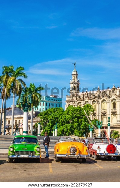 HAVANA, CUBA - DECEMBER 2, 2013:\
Classic American colorful cars one of streets in Havana, where old\
cars bought before Cuban revolution are icon view of Cuba\
