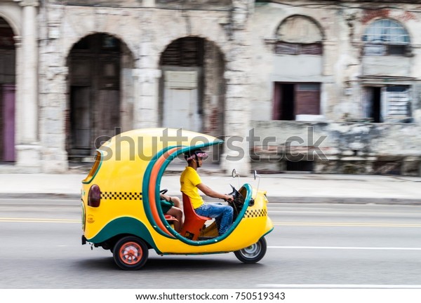 HAVANA, CUBA - FEB 22, 2016: Coco taxi\
rides along the famous seaside drive Malecon in\
Havana