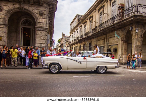 HAVANA, CUBA - FEBRUARY 6: A couple being driven\
around town before their wedding on February 6th 2009 in Havana,\
Cuba. As per tradition, they must visit most popular places, such\
as Malecon street.