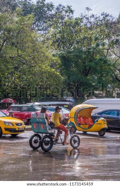 Havana, Cuba - january 15, 2016: Cycle-taxis and\
coco-taxis near Central Park in the historic center of the city,\
after a day of heavy\
rain