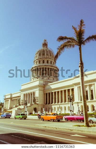 HAVANA, CUBA - JANUARY 16, 2017: A vintage car
circulating in front of the Capitol in Havana, Cuba. Cubans, unable
to buy newer models, keep thousands of them running. Image with
vintage effect