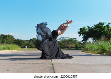 Havana, Cuba. January 7, 2021. Young Ballerina Dressed In Black Dancing On Street Against Clear Sky