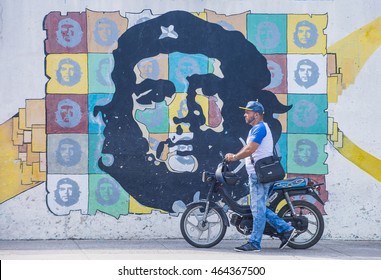 HAVANA, CUBA - JULY 18 : A Man With A Motorcycle Walking Past A Mural Of Che Guevara In Old Havana Street On July 18 2016. The Historic Center Of Havana Is UNESCO World Heritage Site Since 1982.