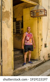 HAVANA - CUBA JUNE 19, 2016: Cuban Man Stands In The Doorway Of His Home, With Its Antique Birdcage, That Is One Of Thousands Of Deteriorating And Decaying Buildings In La Habana Vieja.

