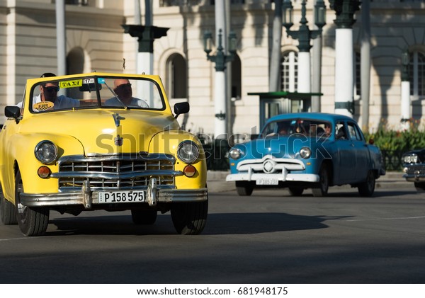 Havana, Cuba - June 27, 2017: American\
convertible yellow classic car on the crossroad in Havana Cuba-\
Serie Cuba Reportage