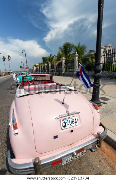 HAVANA, CUBA - JUNE 29, 2015: Rear view of a pink\
classic car with a cuban\
flag