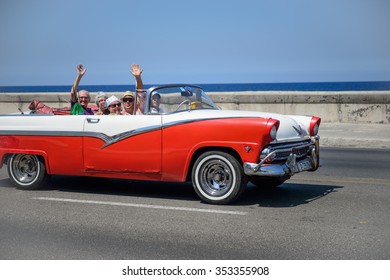 Havana, CUBA - March 18: A group of tourists enjoying a taxi ride in a vintage 1950s car along the promenade in Havana, Cuba