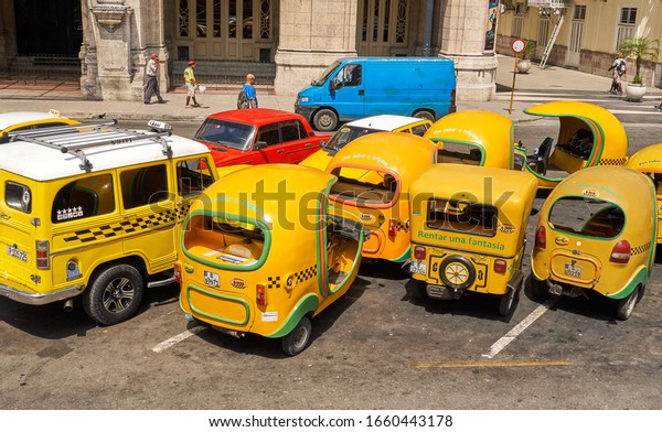 Havana, Cuba - May 08,\
2019: Yellow taxi on Havana street in Cuba. Taxi is one of the\
methods of travelling around Cuba which tourists choose. Parque\
Central - Central Park