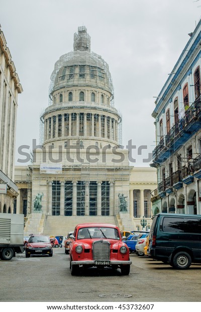 HAVANA, CUBA - MAY 16, 2016: View\
to the Capitol. Retro car is riding on the street of\
Havana.