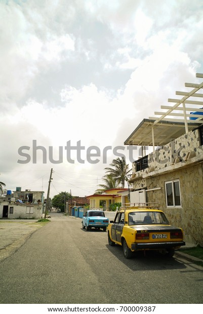 Havana, Cojímar, Cuba, MAY 17, 2017: Cars parking\
beside the house in Cojímar, Cojímar is a small fishing village\
east of Havana,It was an inspiration for Ernest Hemingway\'s The Old\
Man and the Sea