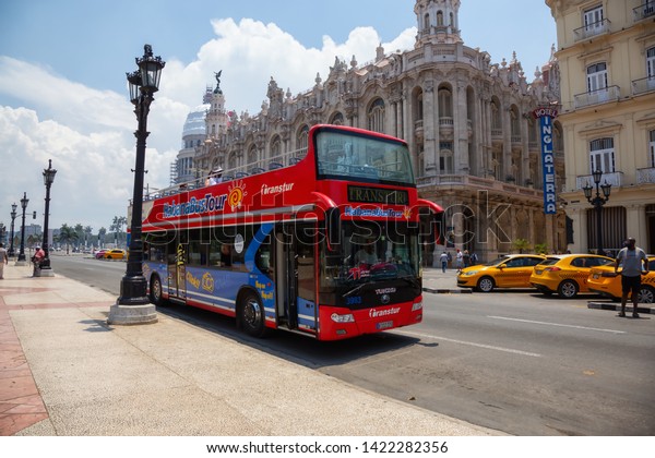 Havana, Cuba - May 19, 2019: Touristic Bus Tour, Hop\
on Hop Off, in the streets of the Old Havana City during a vibrant\
and bright sunny day.