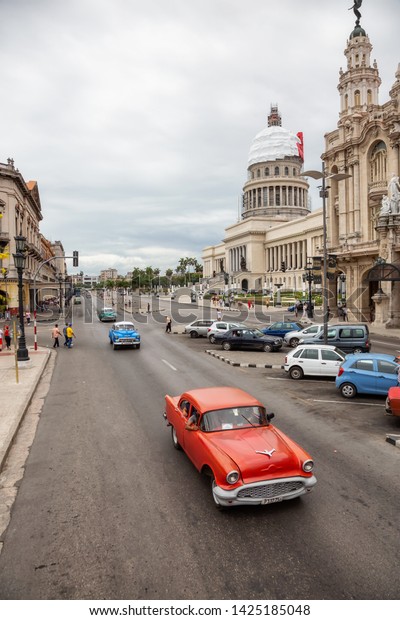 Havana, Cuba - May 23, 2019: Aerial View of an\
Old Classic American Car in the streets of the Old Havana City\
during a vibrant and bright sunny\
day.
