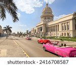 Havana, Cuba - November 16th 2023 - Street view of vintage convertible cars driving in front of El Capitolio  