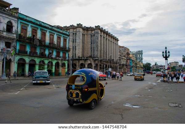 Havana - Cuba / October 16 2011, Life in city\
center of Havana rundown buildings, old Cuban cars and Coco taxi\
passing along.