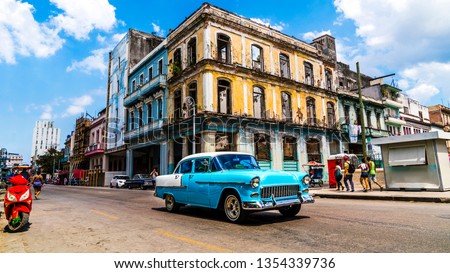 Havana, Cuba. Vintage classic American car on the streets of the famous vibrant vibrant capital also known as Habana. A spontaneous moment  of cheerful tourists enjoying their beautiful vacation.