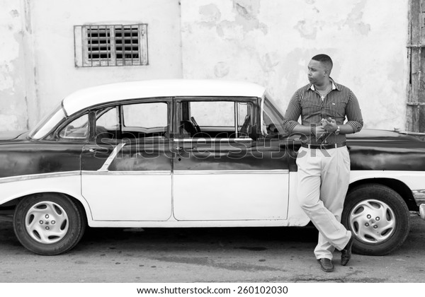 HAVANA -\
FEBRUARY 17: Unkown man staying on his classic car on February 17,\
2015 in Havana. Havana is the capital city, province, major port,\
and leading commercial centre of\
Cuba