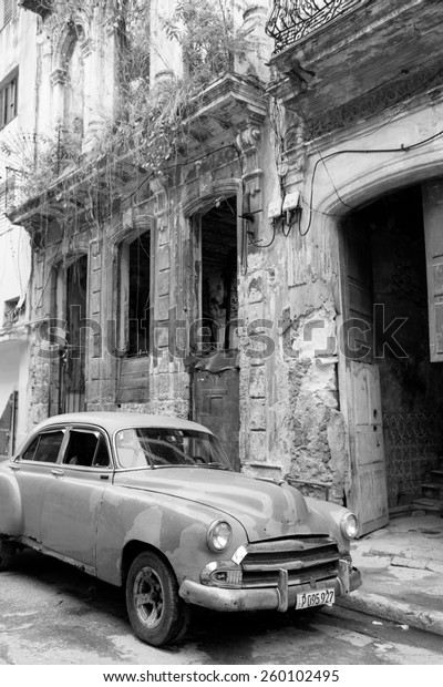 HAVANA - FEBRUARY 18: Classic car and antique\
buildings on February 18, 2015 in Havana. These vintage cars are an\
iconic sight of the\
island
